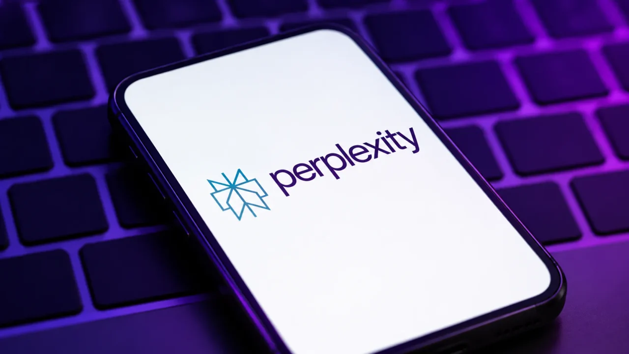 Điện thoại màn hình trắng hiện logo và chữ perplexity, đặt trên bàn phím laptop ánh tím